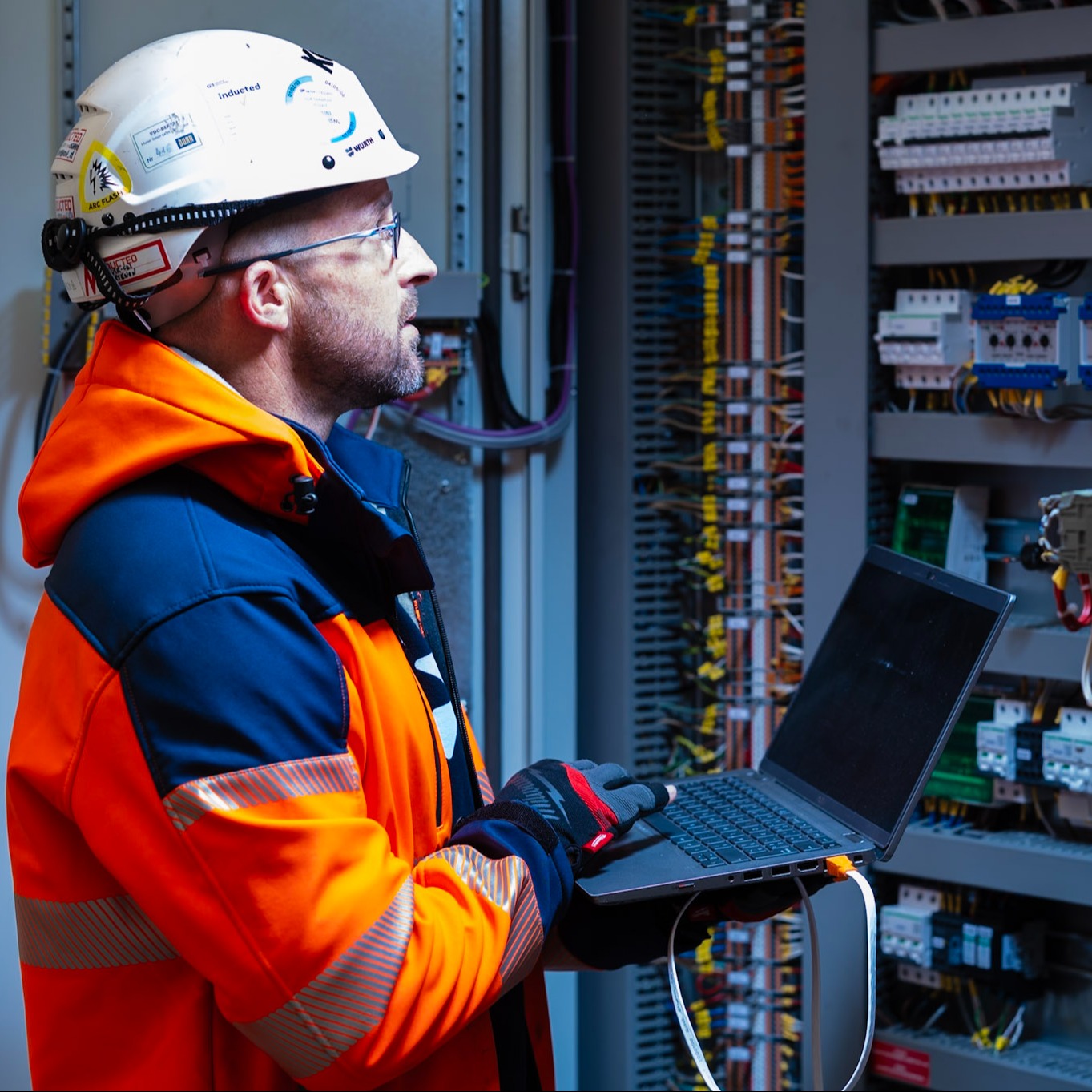 Man looking at a data center rack mounting networking connectors