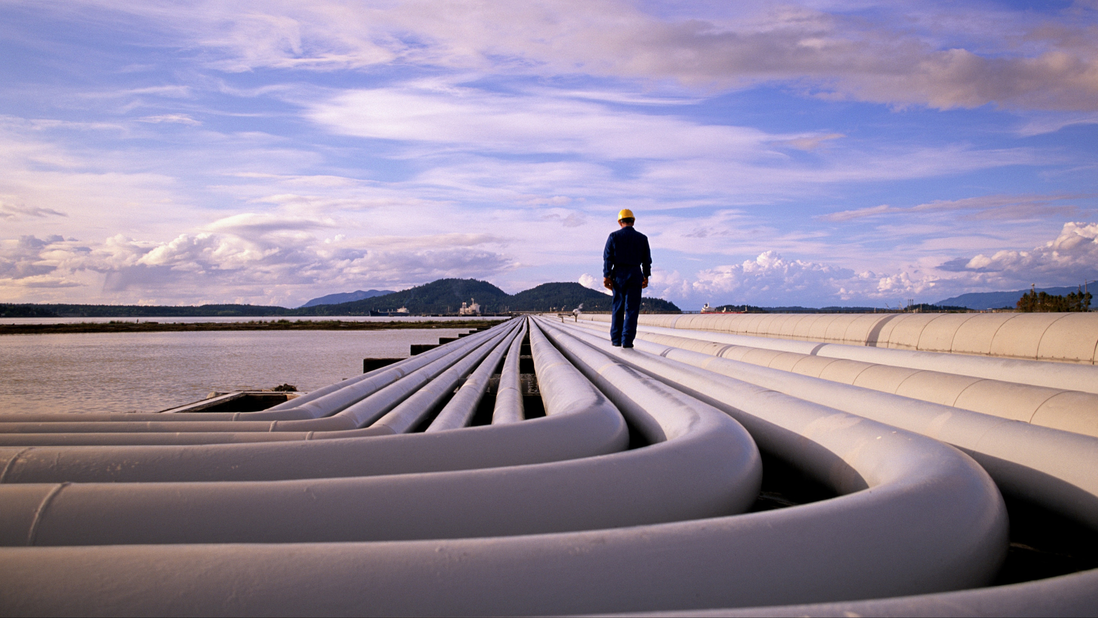 Man walking across pipes at a wastewater treatment plant