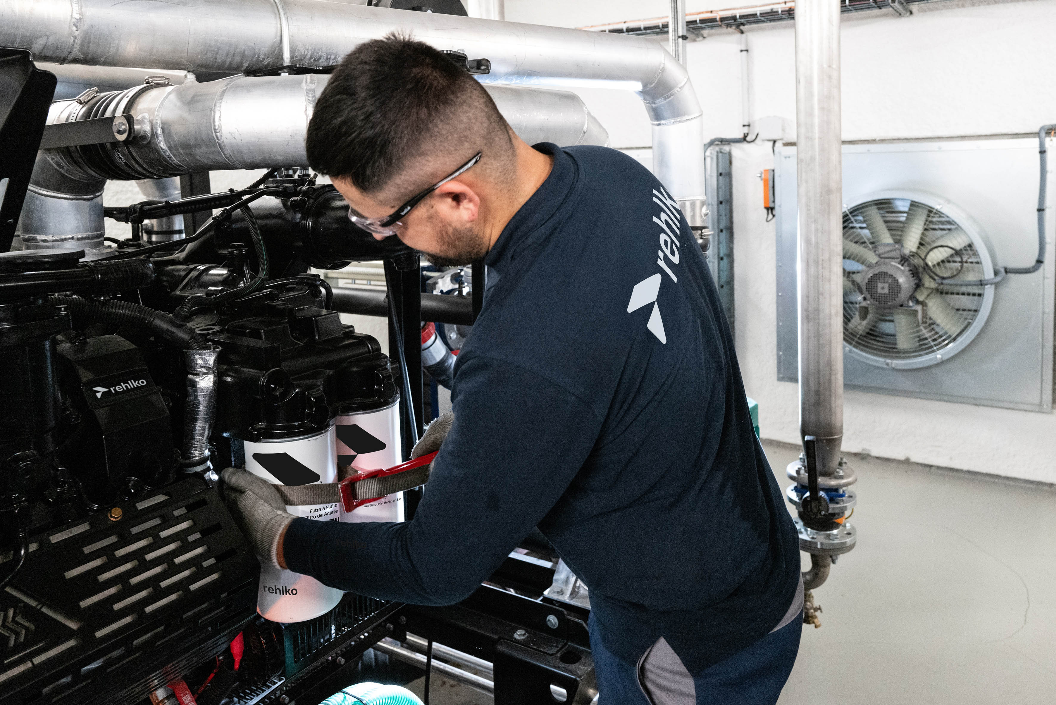 Male professional working on a generator inside a building