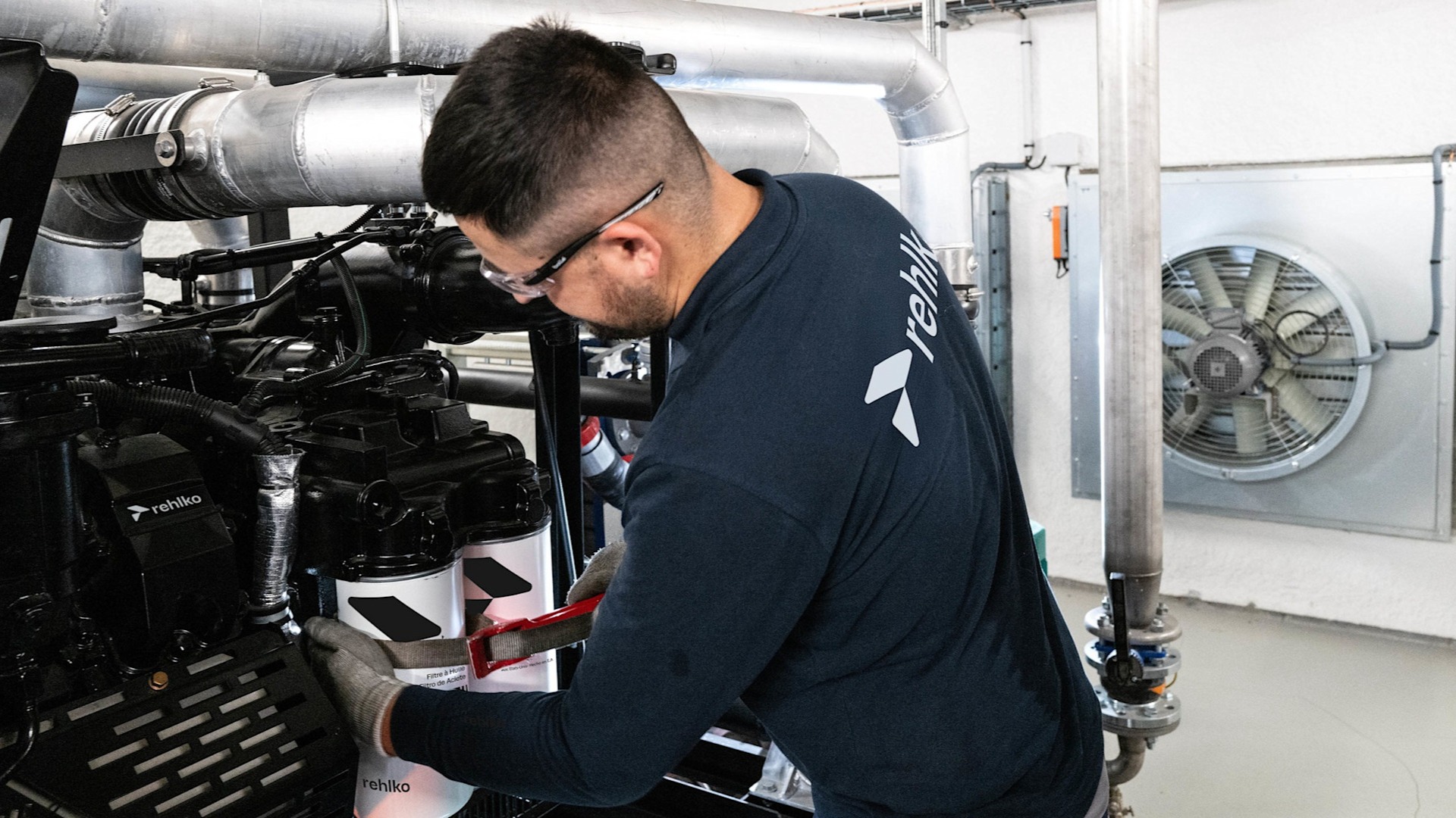 Male professional working on a generator inside a building