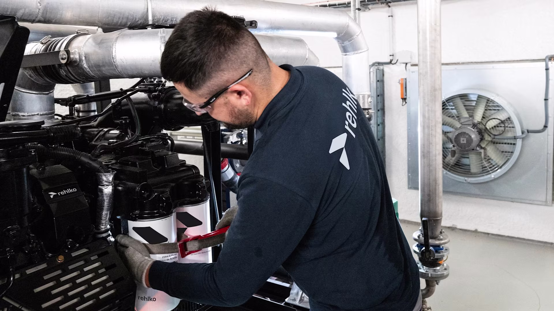 Male professional working on a generator inside a building