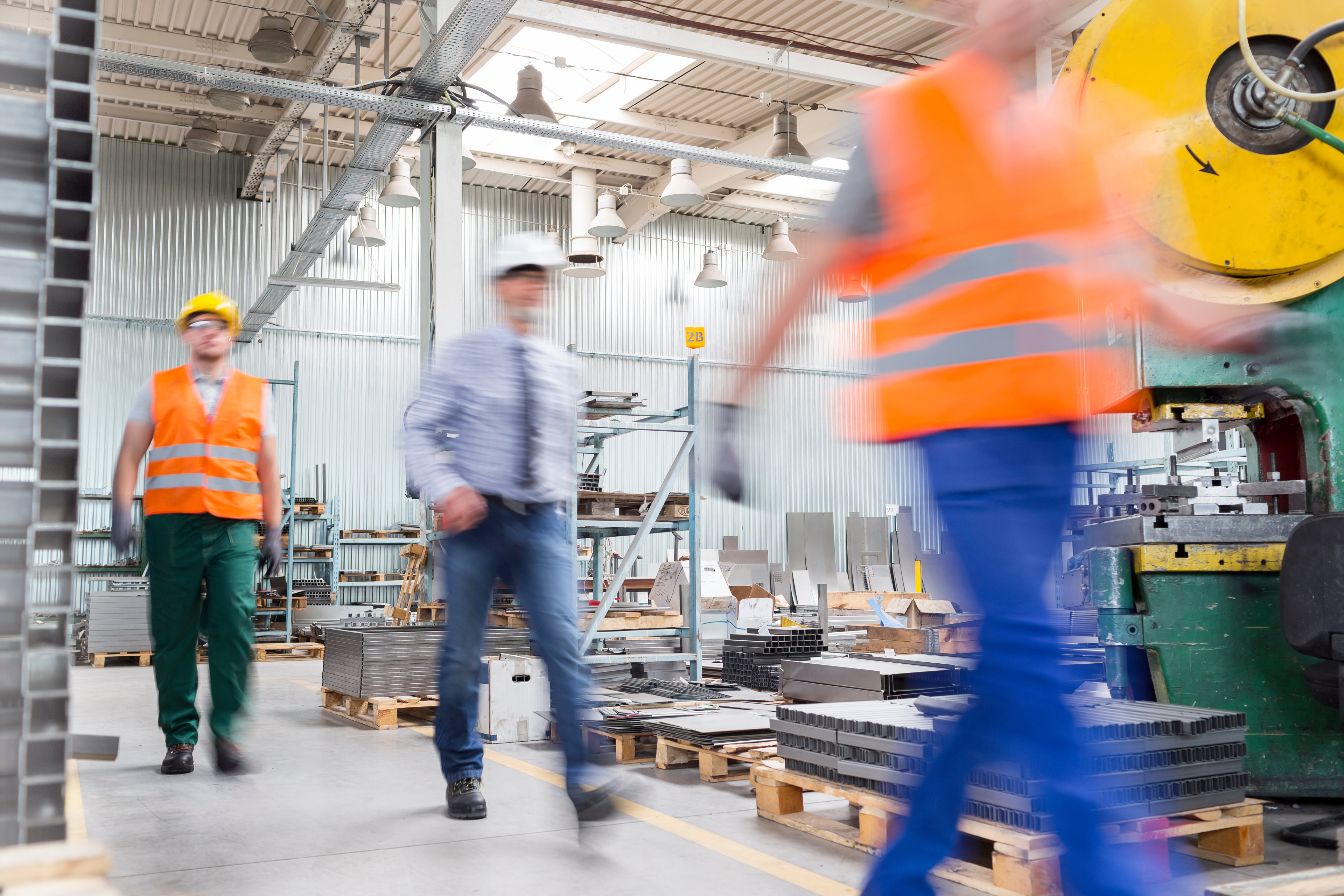 Blurred image of men walking on a warehouse.
