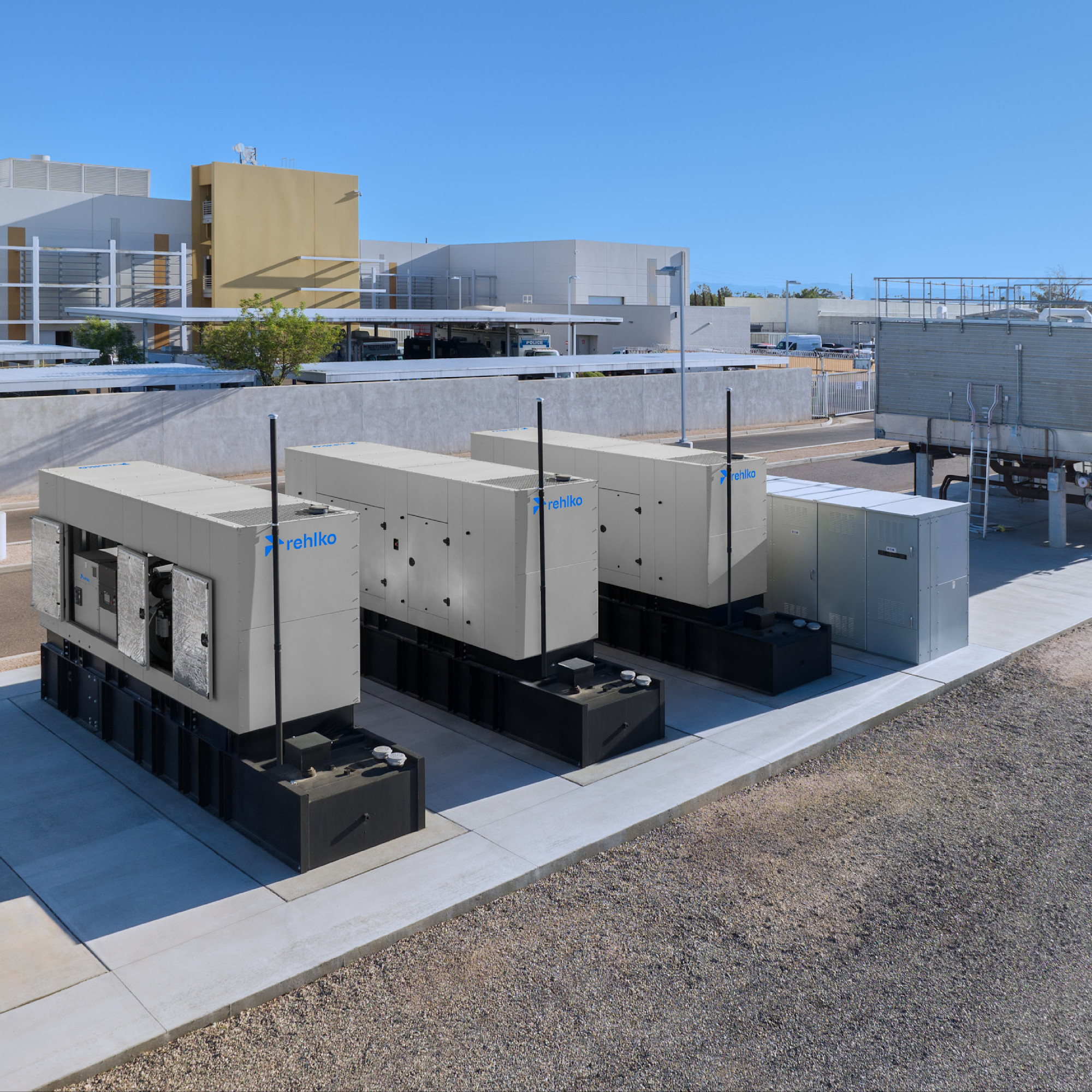 Three Rehlko generators installed on the rooftop of a building.