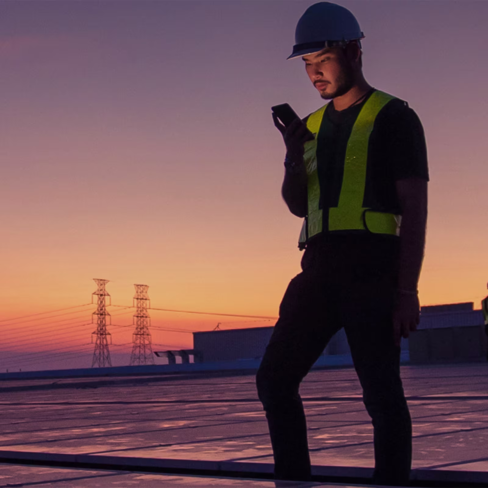 Man on a roof with cellphone at sunset