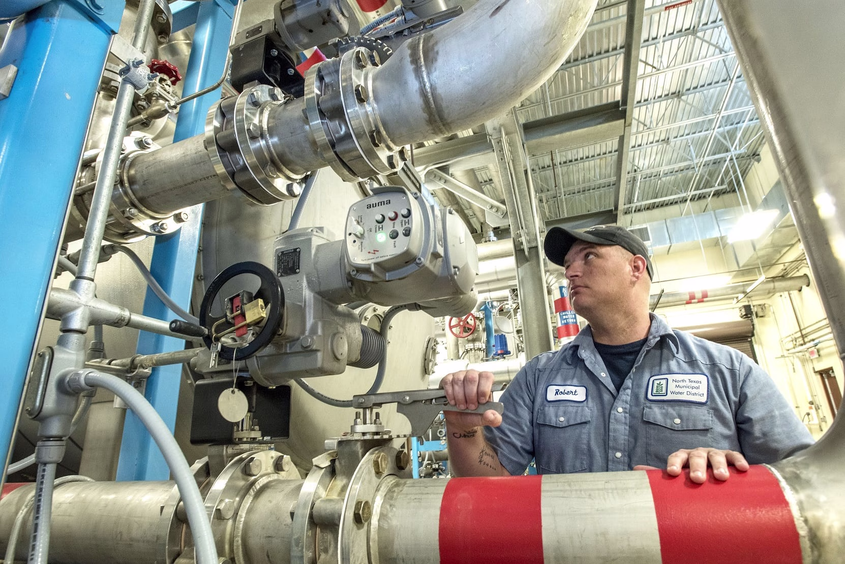 Man in water utility uniform working on water pipes.