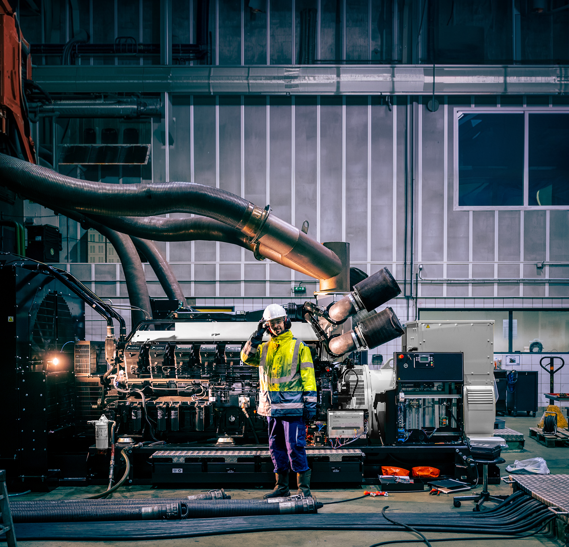 Technician inspecting an industrial diesel generator during performance testing and commissioning.