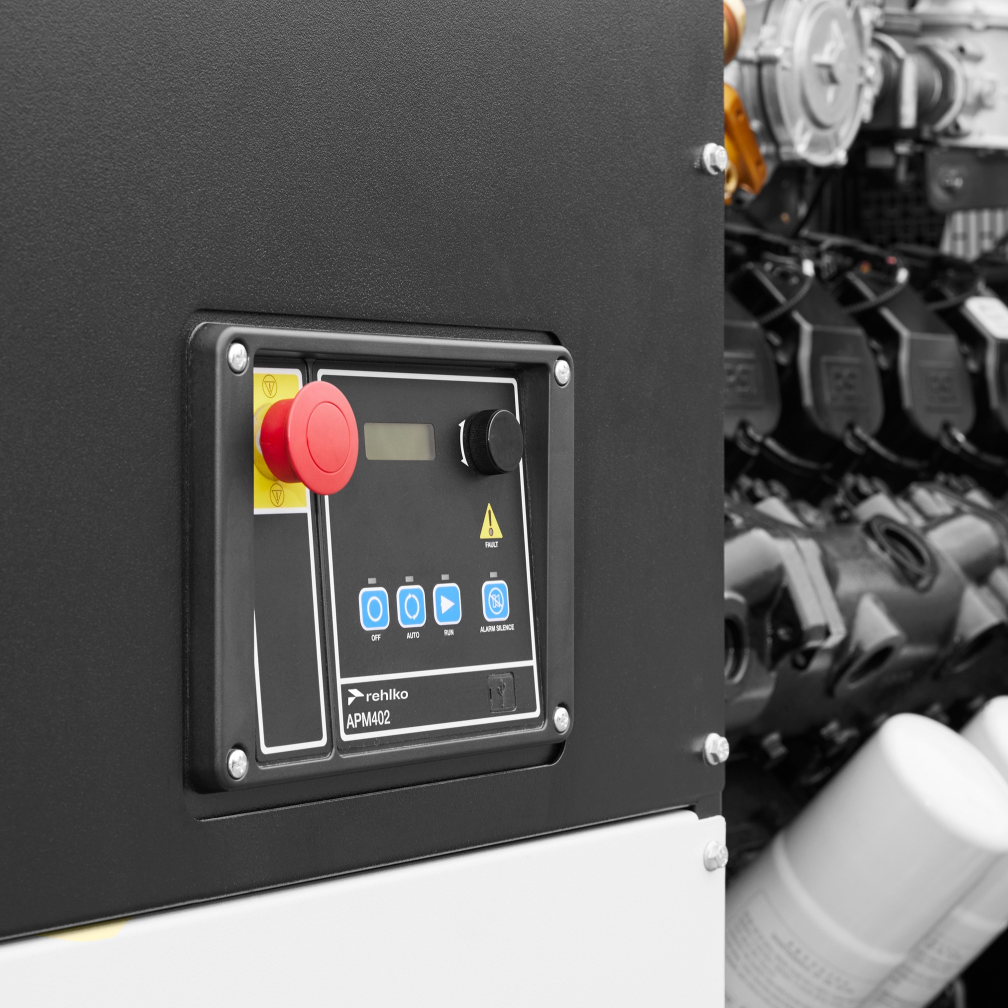 Close-up view of the APM402 controller panel, featuring labeled buttons and a display screen, with the Rehlko logo visible.