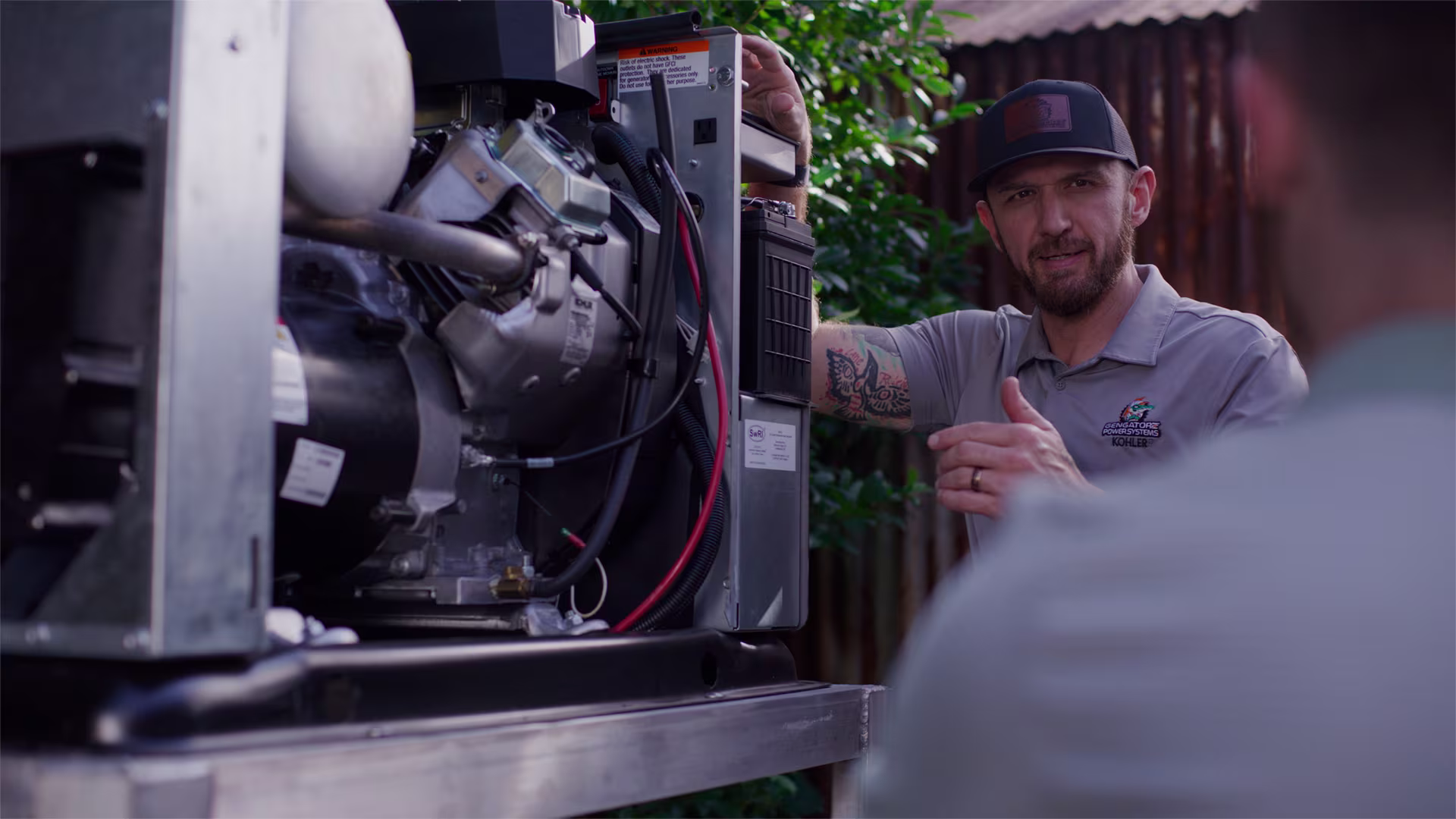 Male technician in front of a open generator