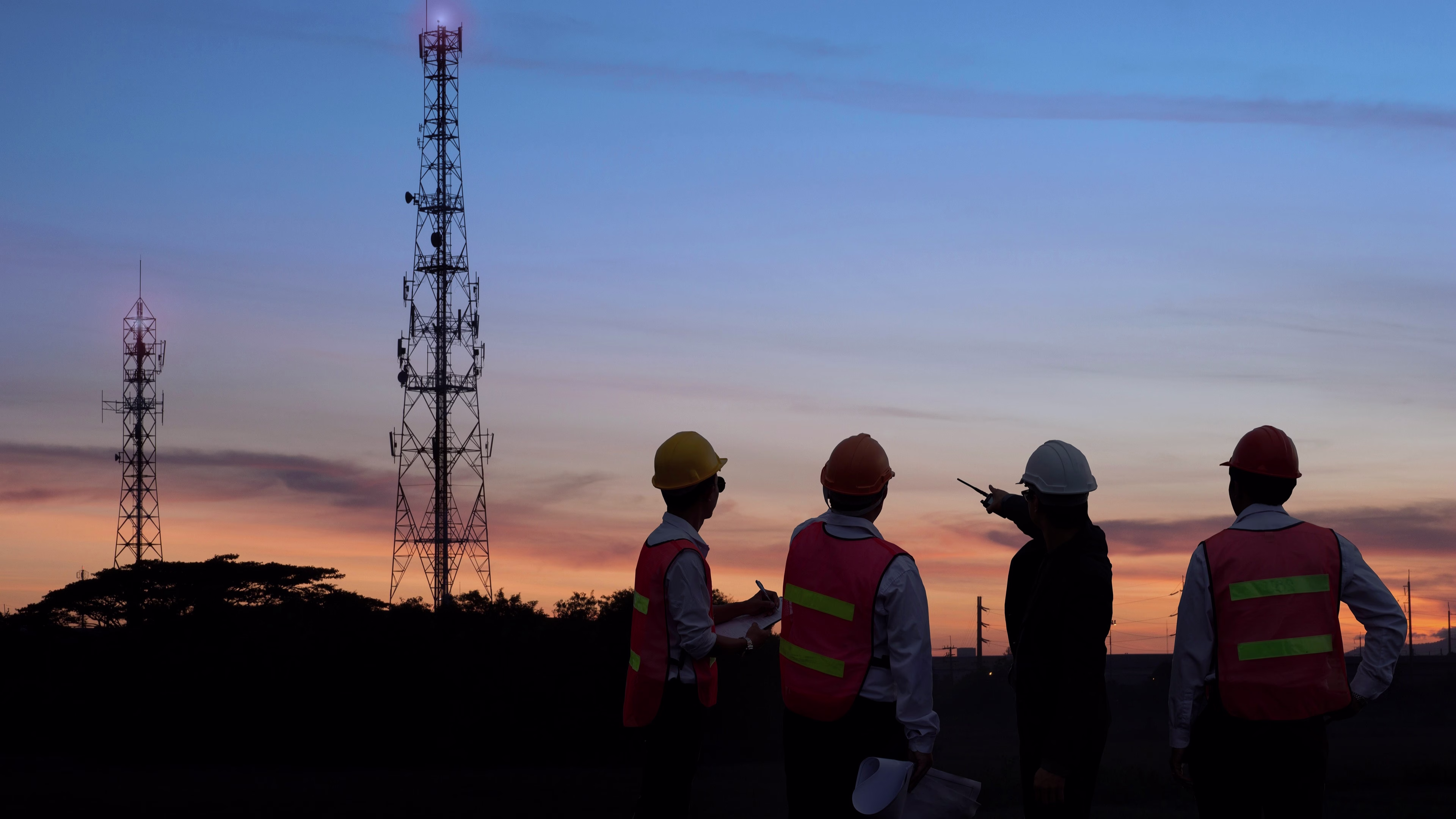 Profesionales de la energía en un sitio de telecomunicaciones que representan soluciones energéticas integradas, resiliencia energética y soporte para infraestructuras críticas.
