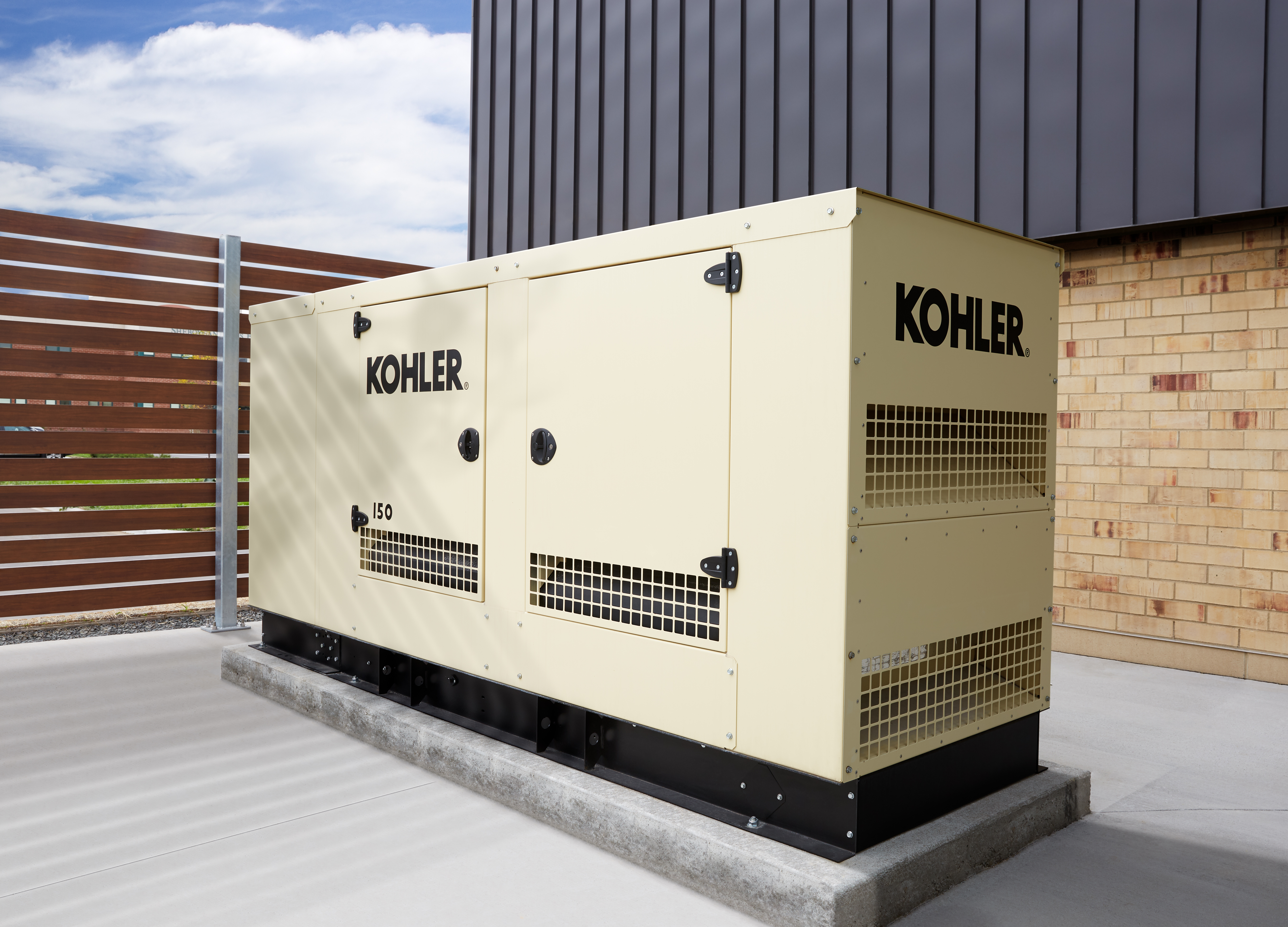 Image of industrial generator outside of an office building surrounded by a fence.