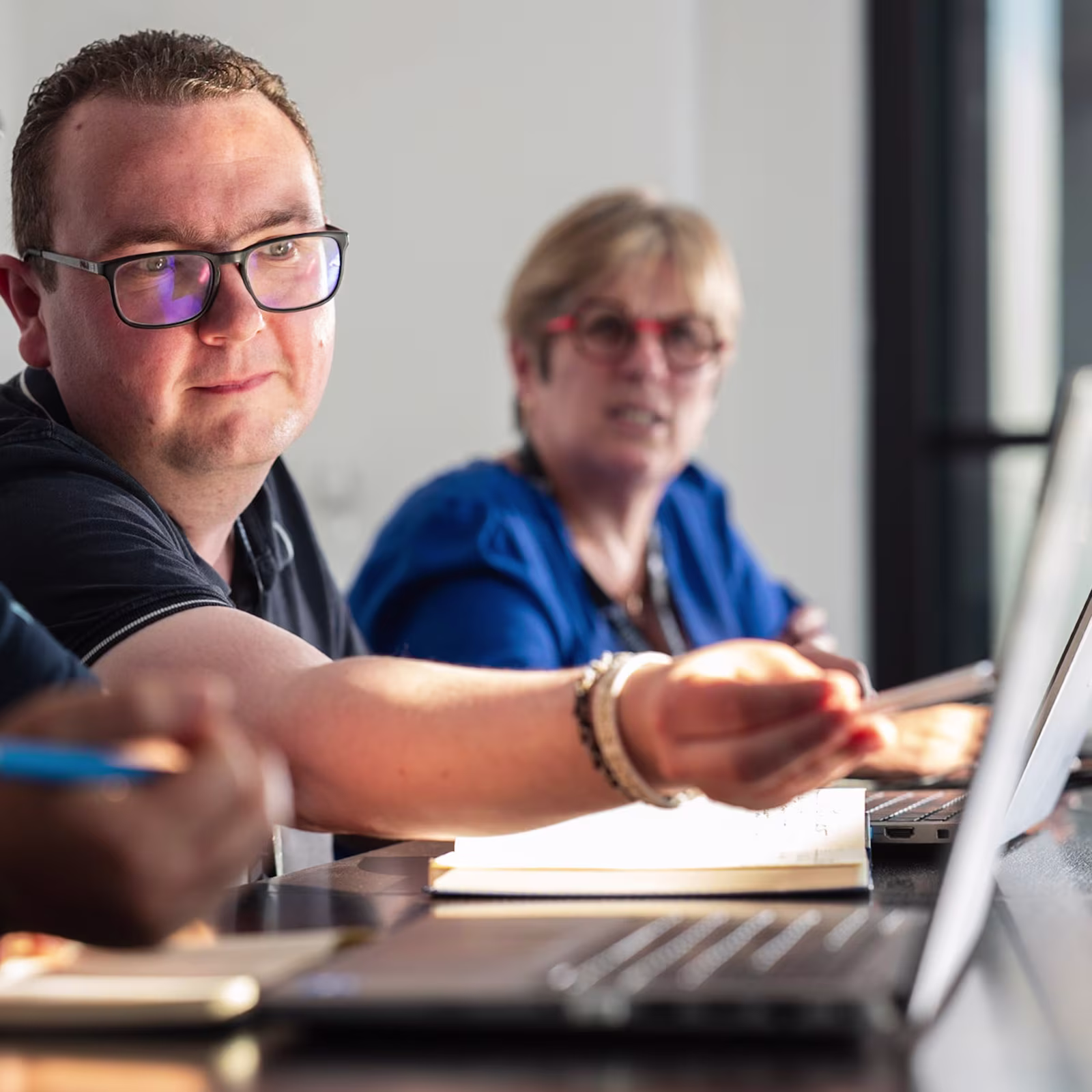 Man pointing to a computer screen during meeting