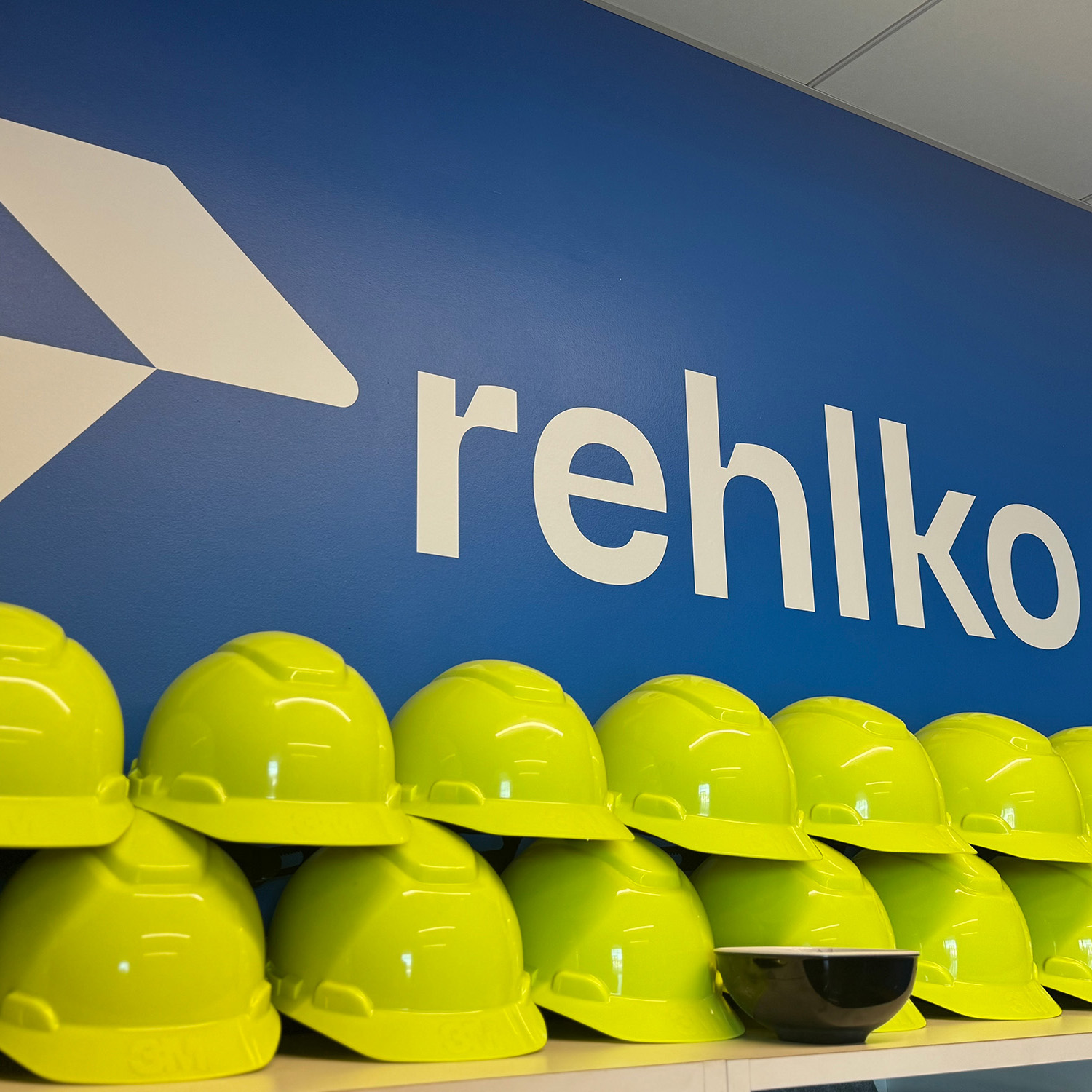 Rehlko sign with yellow hard hats in front of it