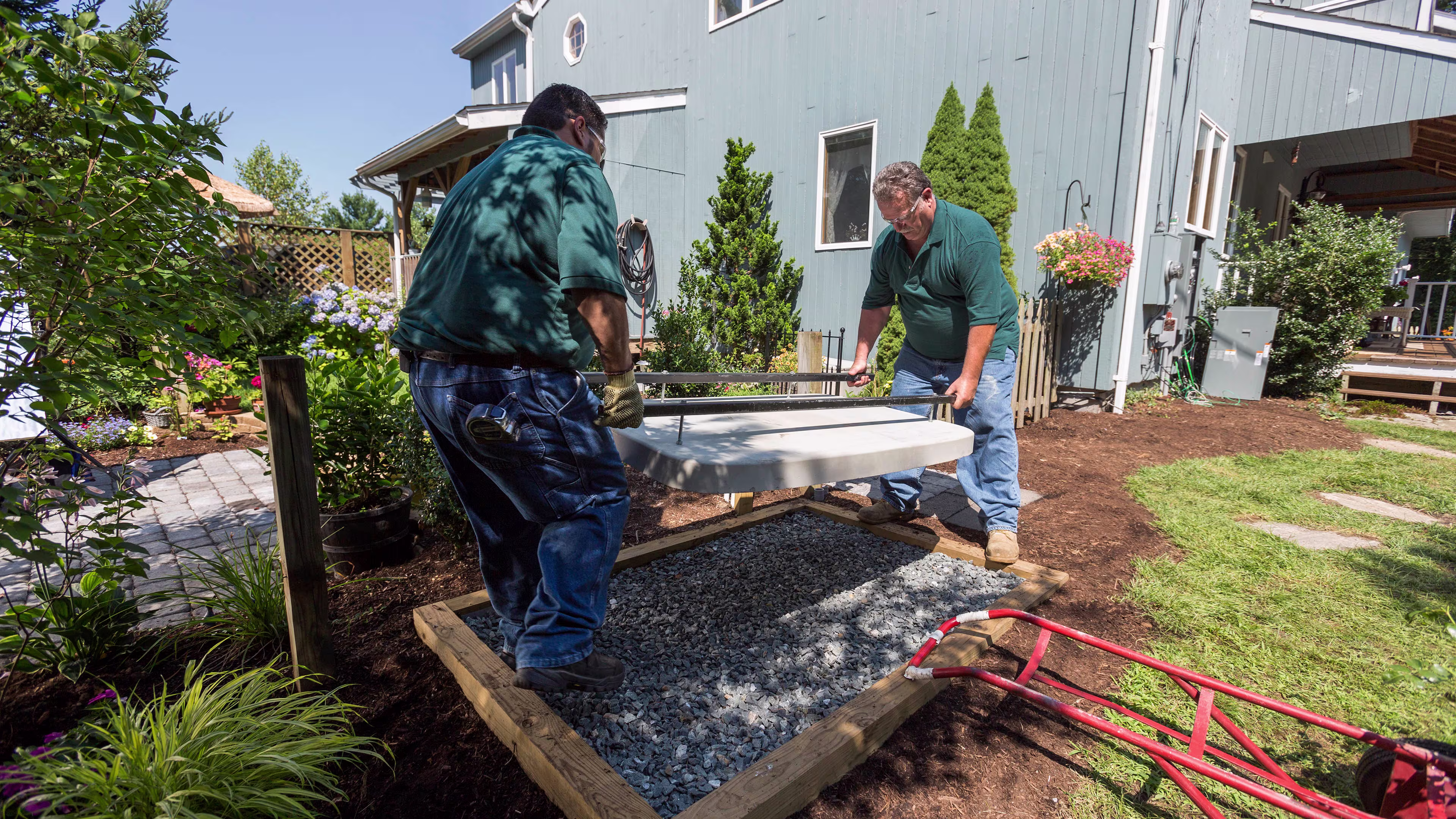 Two professional installers preparing the yard to receive the installation of a home generator.