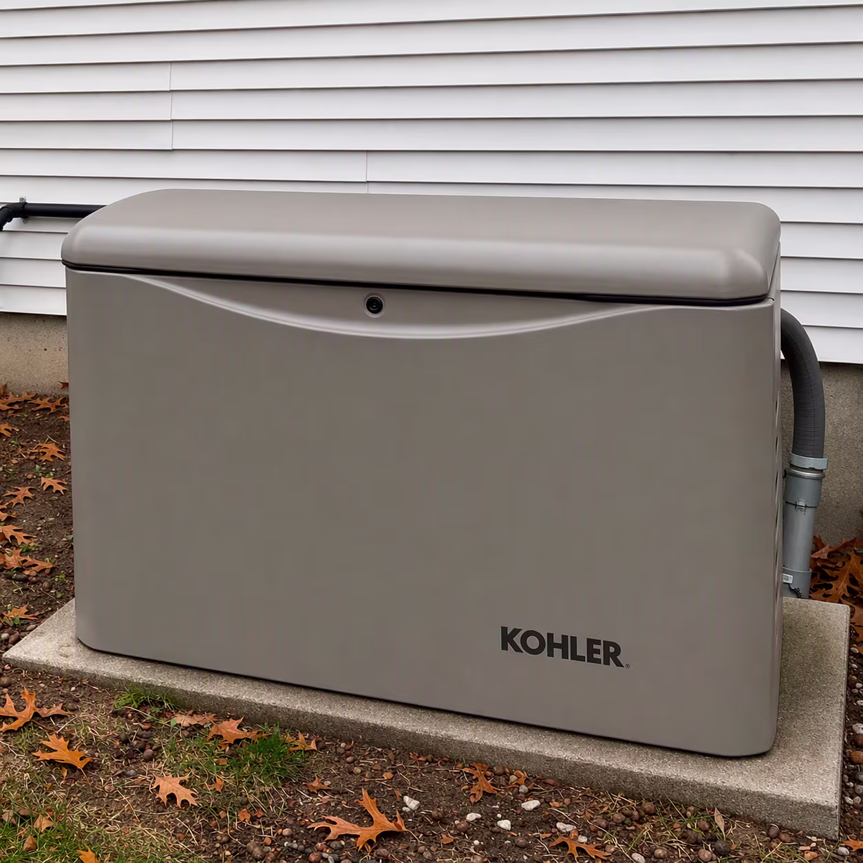 Kohler genertor by a white house with leaves