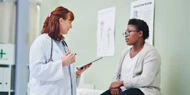 Shot of a doctor using a digital tablet during a consultation with a woman