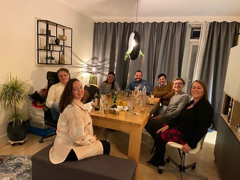 Photo of Vishal Gupta's Elsevier team sitting around a table in the UK for a social gathering. 