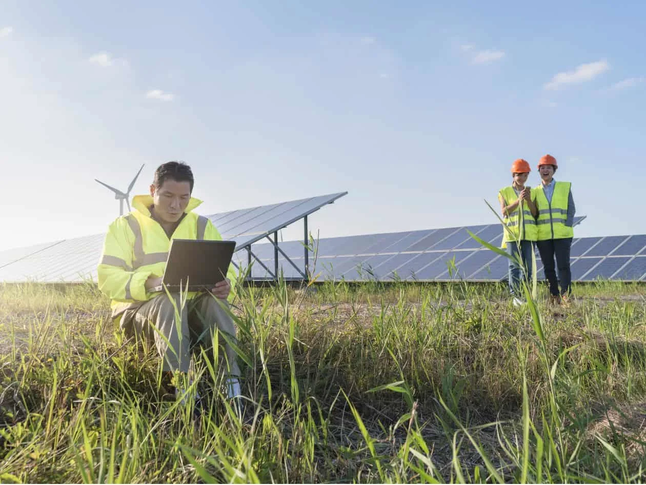 Researchers in the field using a laptop