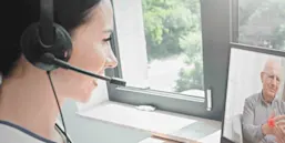 A woman telehealth provider speaks with a geriatic patient.
