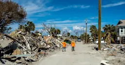 Workers walk along debris on Fort Myers Beach, Florida, after Hurricane Ian in 2022. (© istock.com/Jeff McCollough)