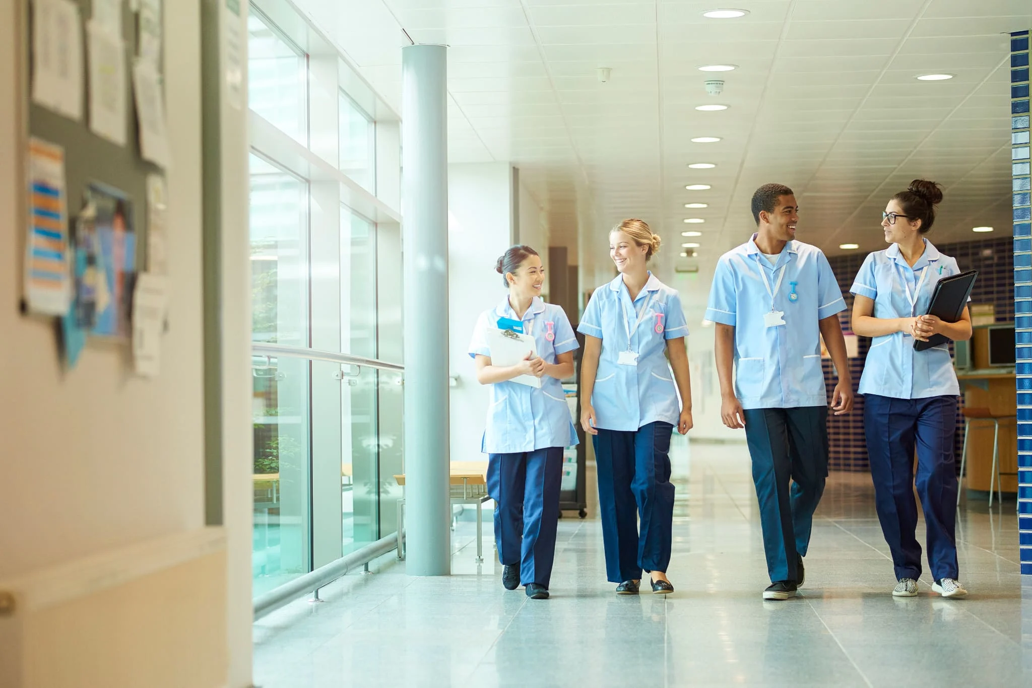 Young trainee nurses walking down hospital corridor