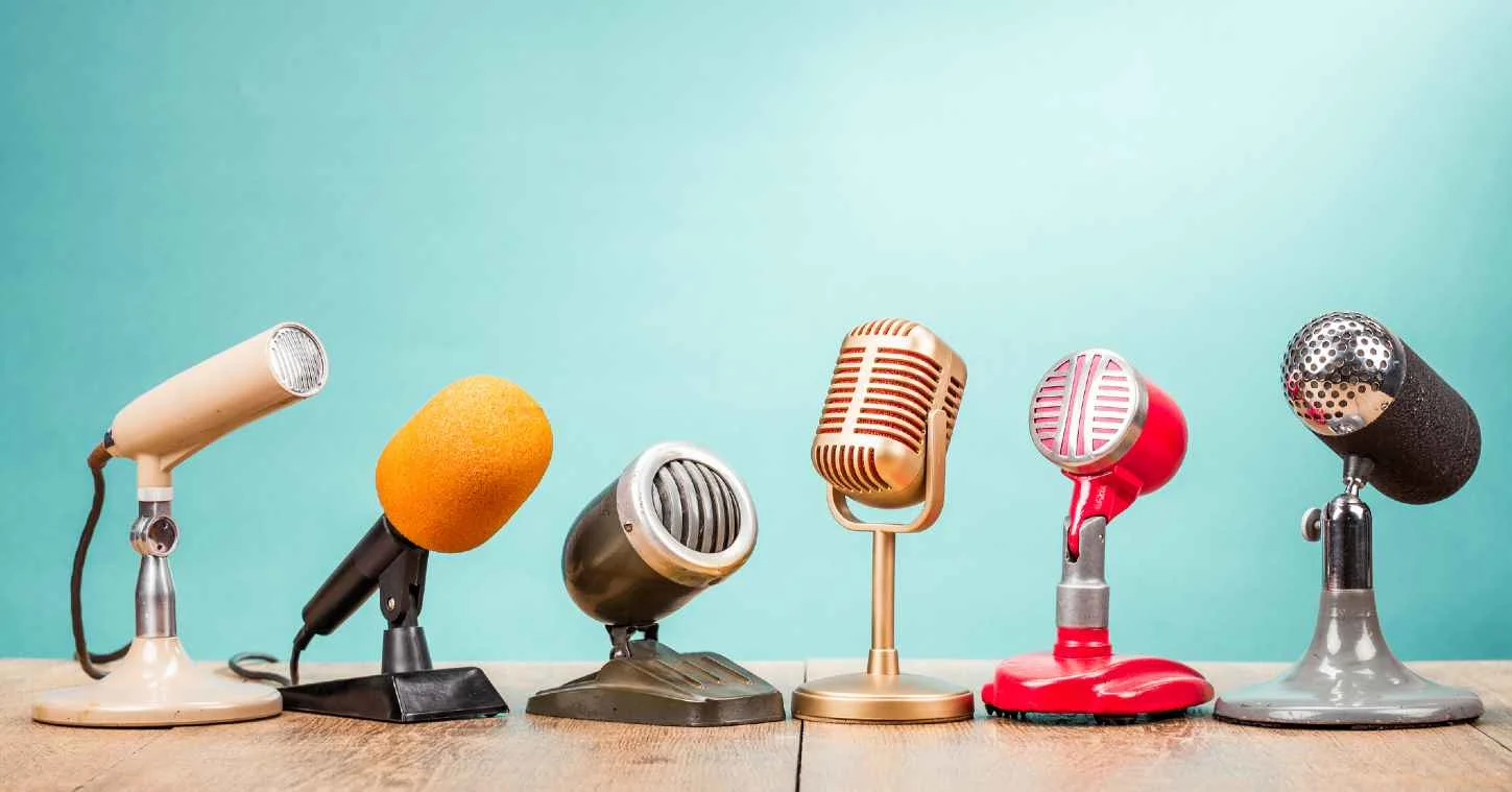 Retro old microphones for press conference or interview on table with blue background