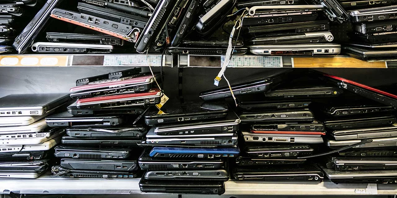 Piles of old discarded laptops on a shelf (Source: Daniel Allan/Image Source via Getty Images)