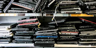 Piles of old discarded laptops on a shelf (Source: Daniel Allan/Image Source via Getty Images)