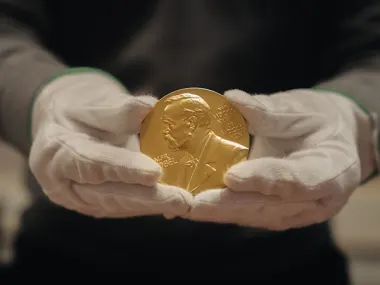  Nobel Prize medal held by gloved hands. © Nobel Prize Outreach. Photo: Clément Morin