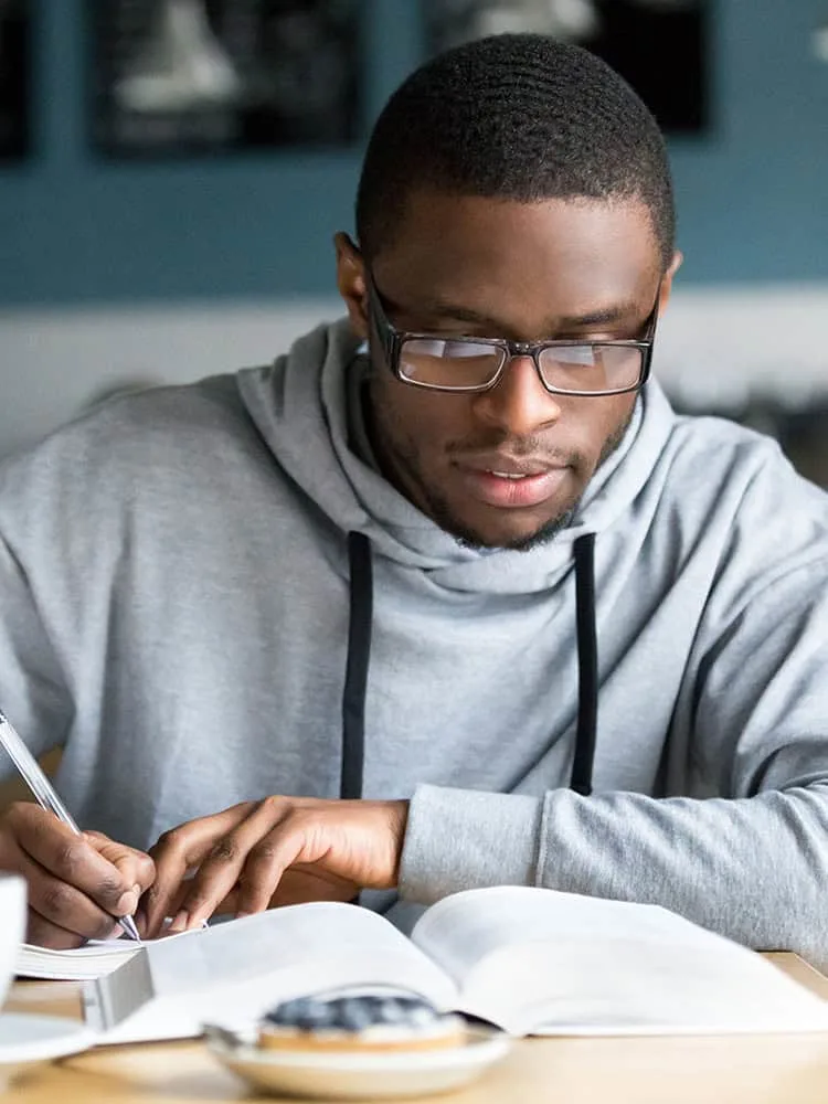 Young student making notes from a text book