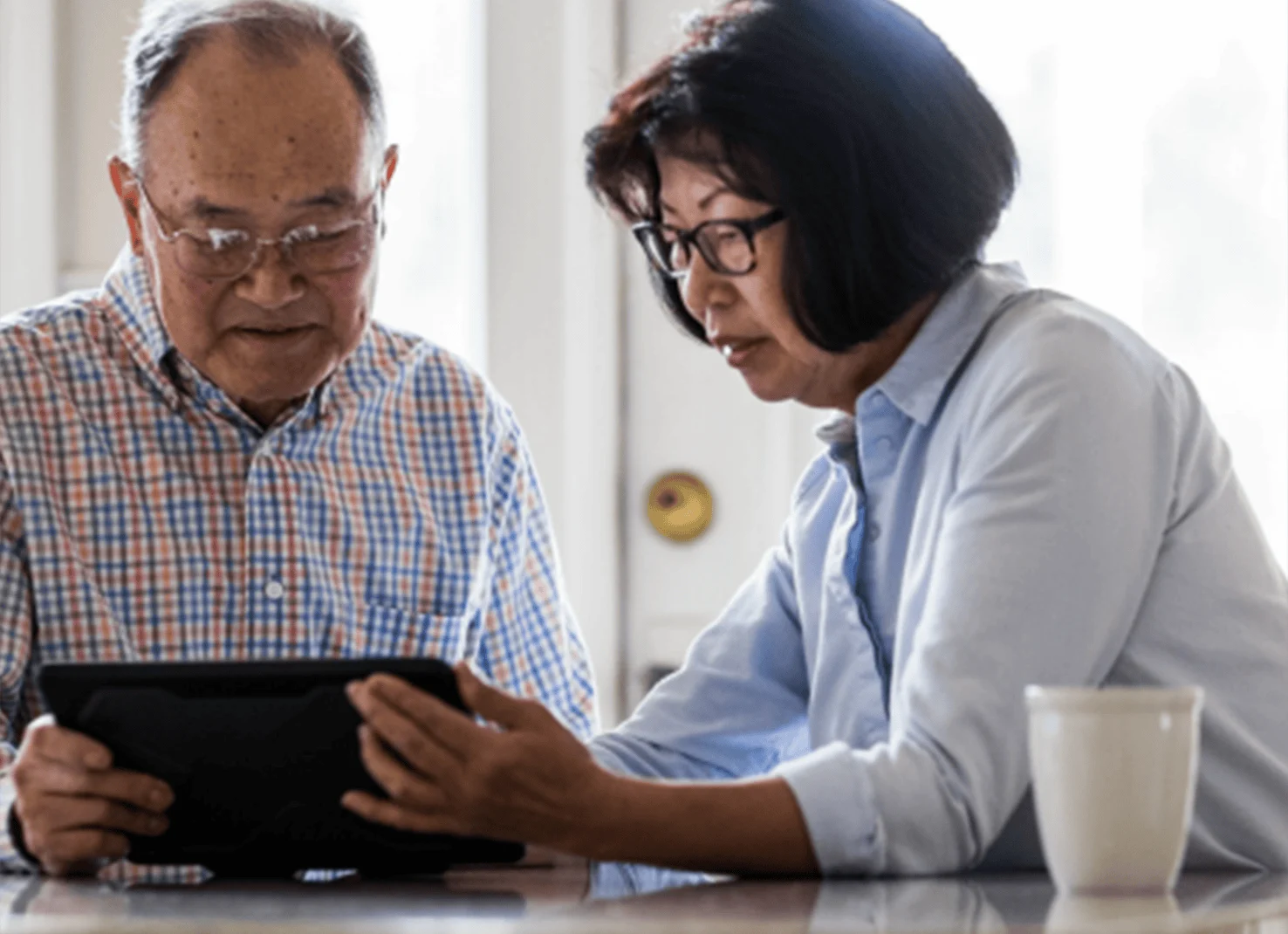Man and woman look at information on tablet