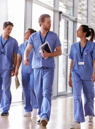 Group of clinicians walk through hospital hallway