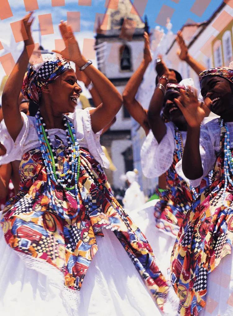 Female dancers wearing beads and clapping in the street