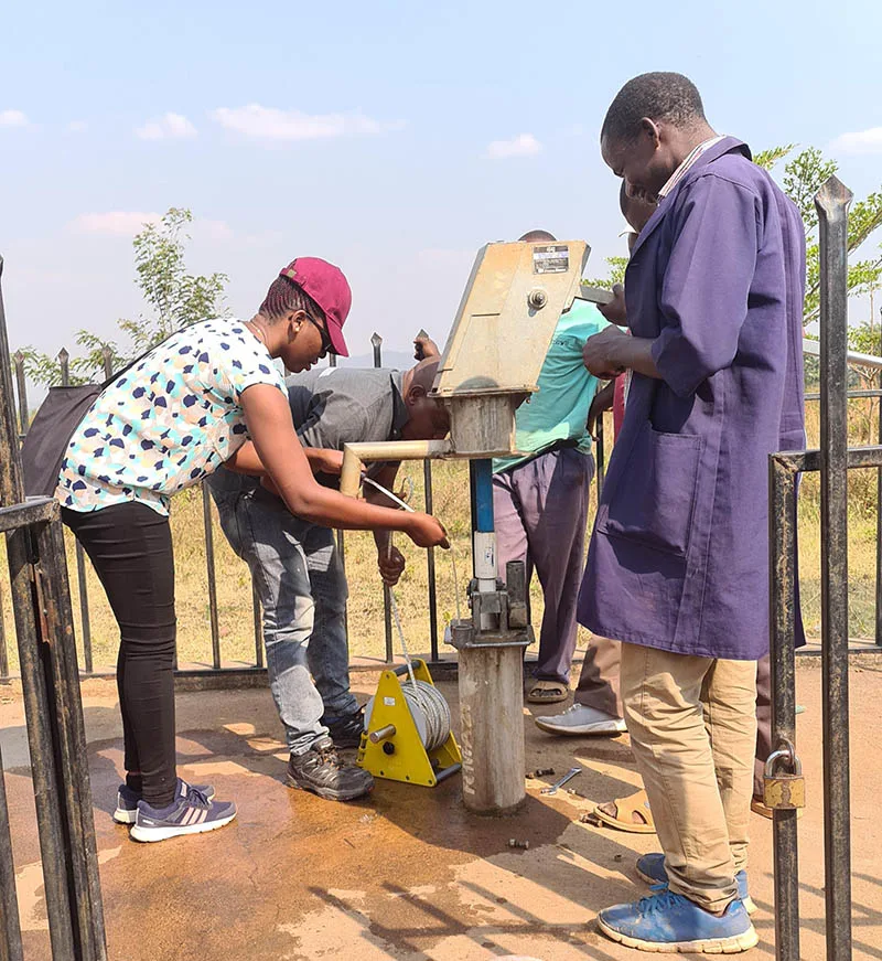 Dr Augustina Alexander measures groundwater levels during a field survey with colleagues from the Rufiji River Basin office.