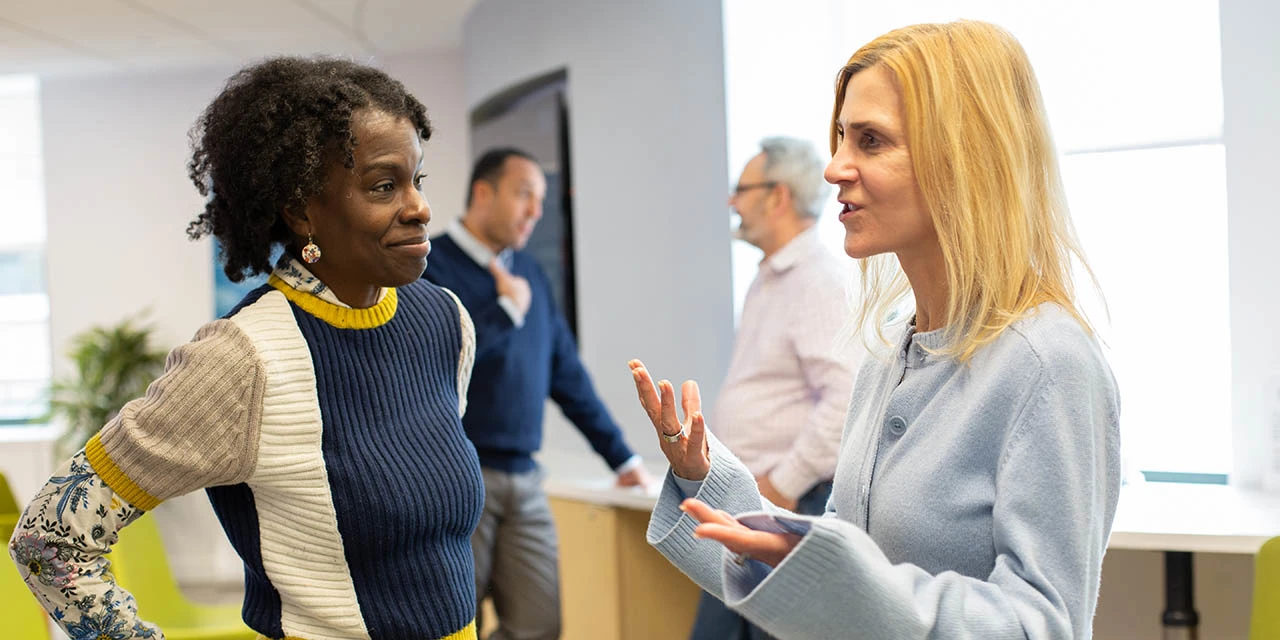 Angelica Kerr (left), a Data Reporting Analyst at Elsevier, talks with Judy Verses, President of Academic & Government Markets, in Elsevier’s New York office. (Photo by Alison Bert)