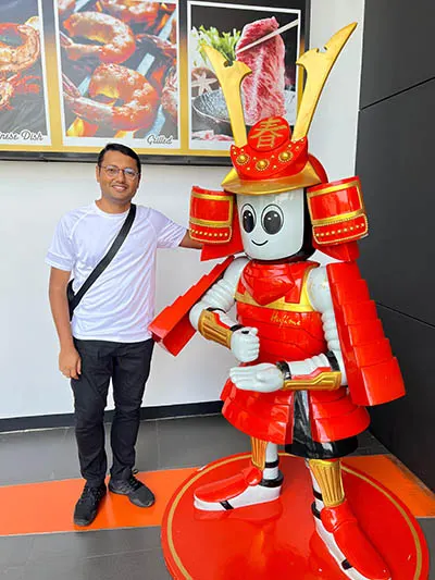 HM Kamrul Hassan poses with a humanoid at Hajime Robot Restaurant in Bangkok, Thailand, where robots take orders and serve food. He visited the restaurant as part of his work with humanoid service robots. 
