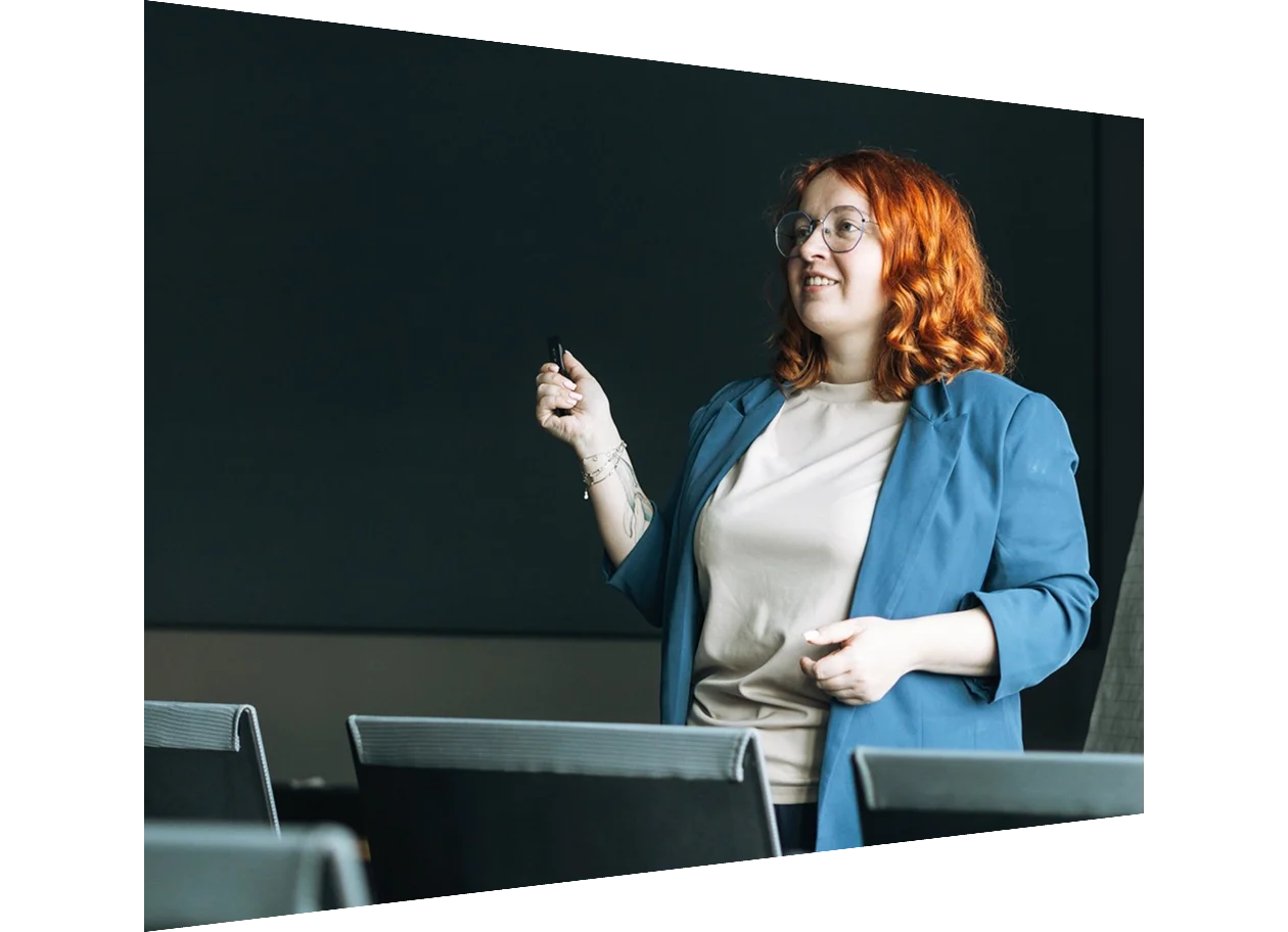 Young red haired woman giving a presentation in a conference room