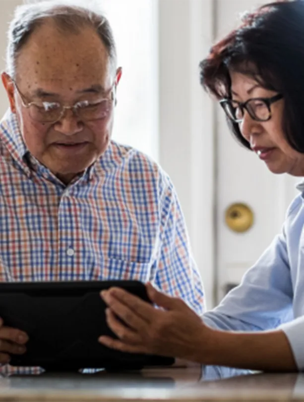 Man and woman look at information on tablet