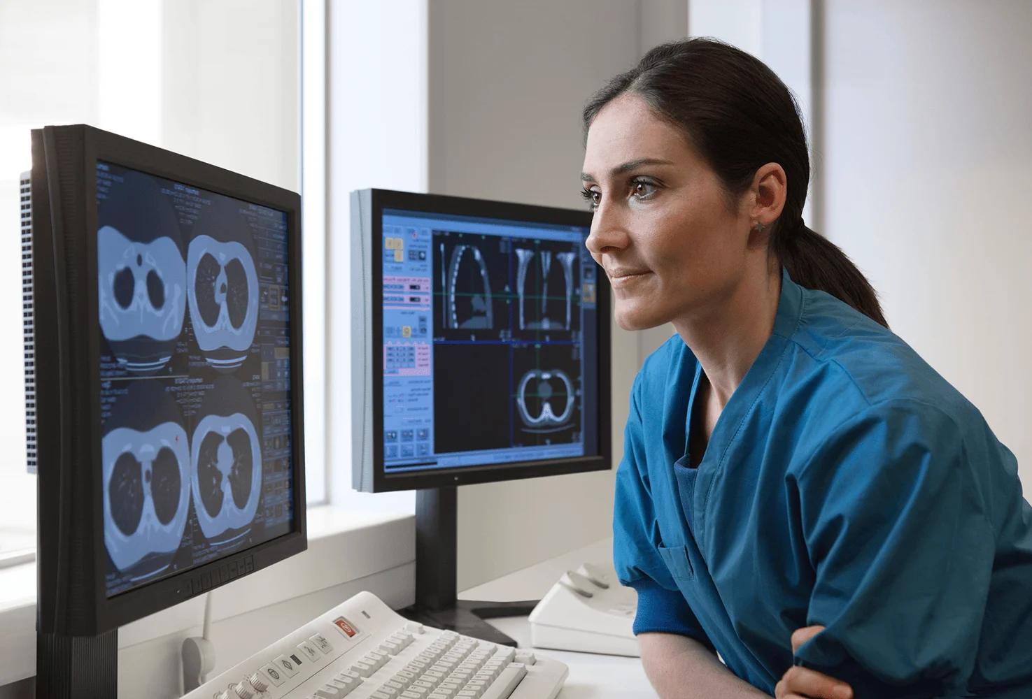 Radiologist reviewing scans on screens