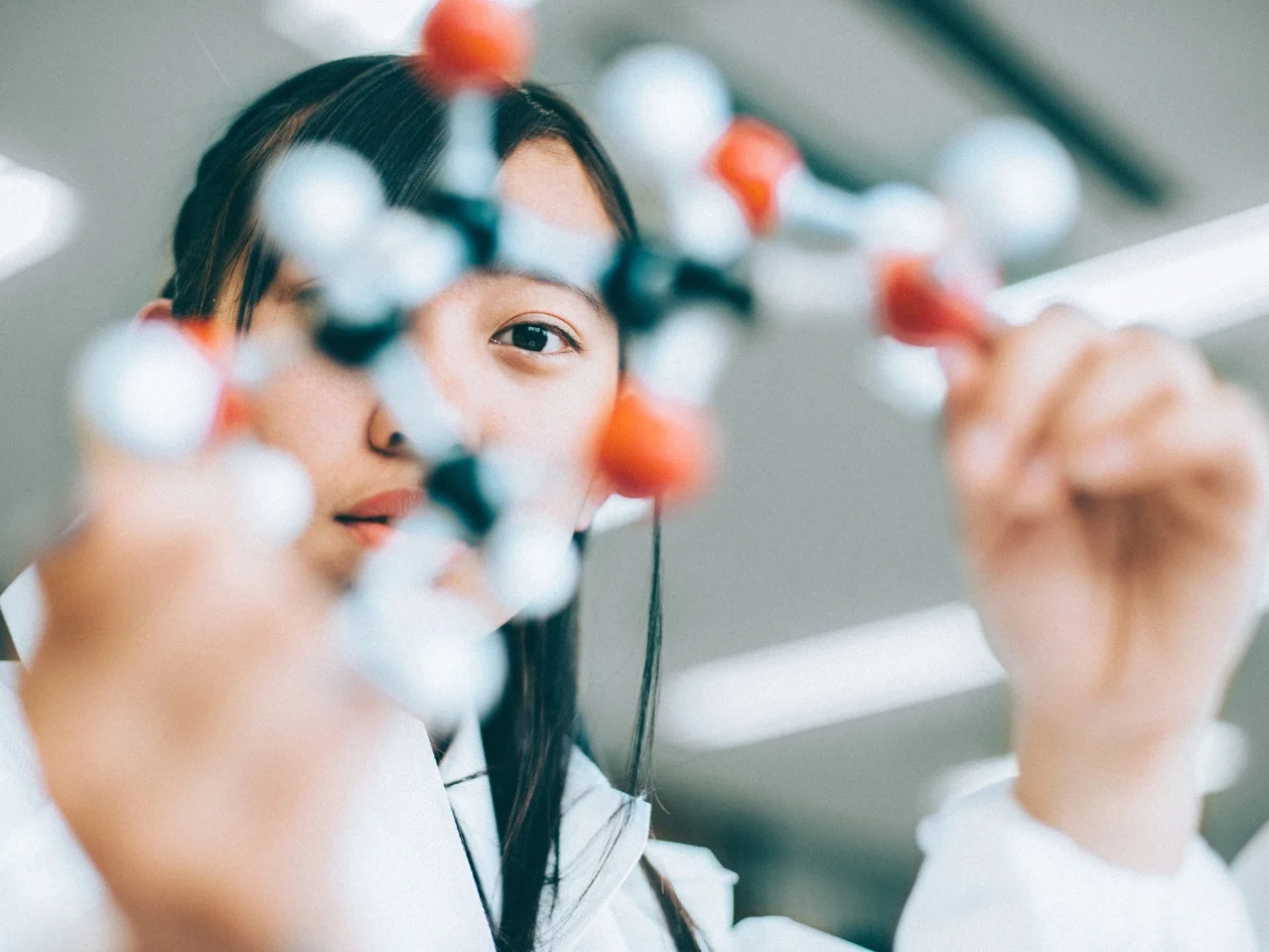 A woman holding a molecule replica