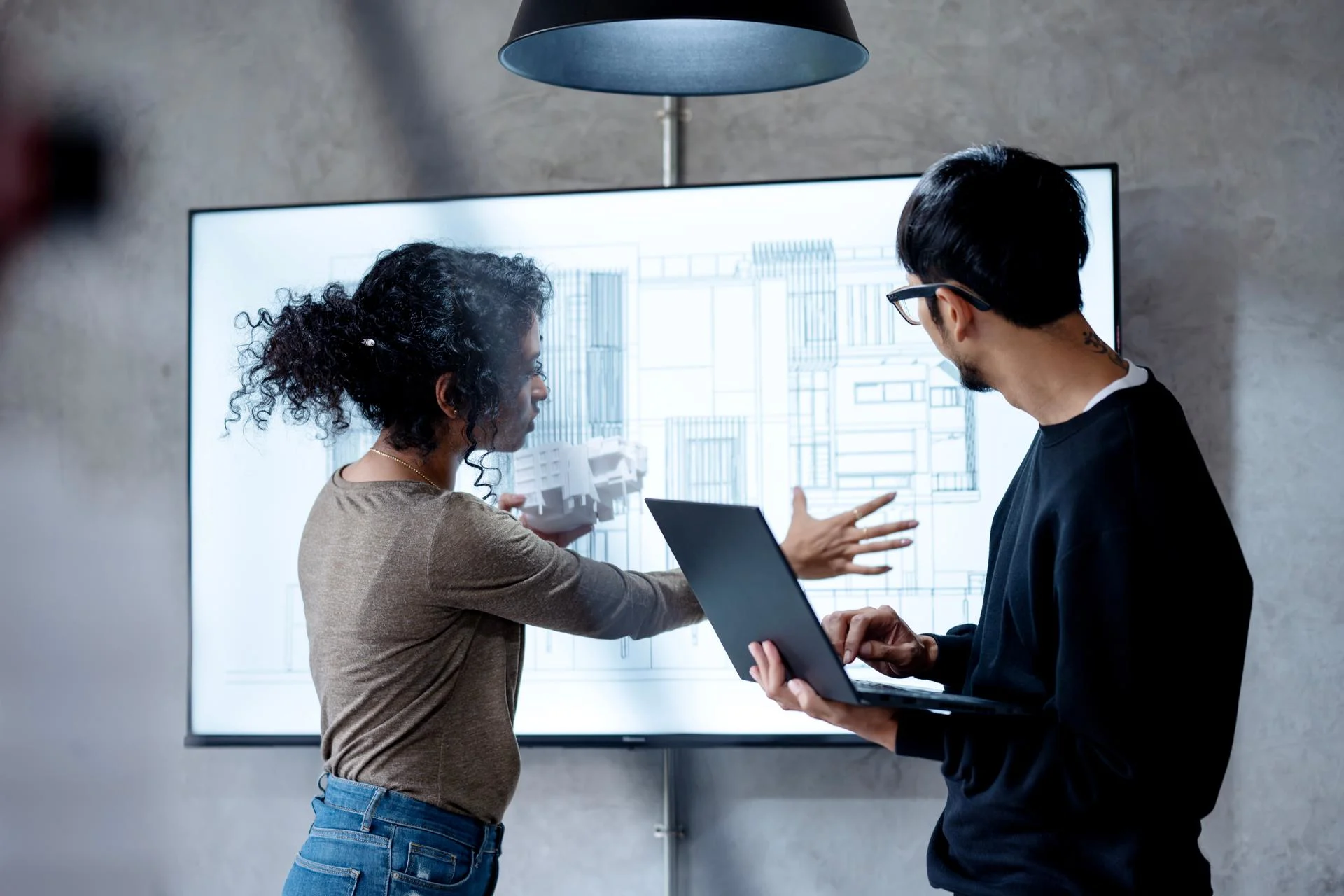 Increased collaboration and coordination in your construction project with BIM technology. Construction project manager and designer on building design review over a digital display to reduce error during the const