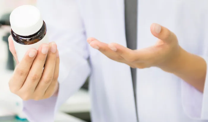 Pharmacist reading bottles of pills