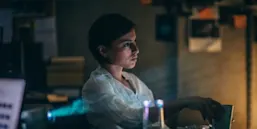 The guardians of Scopus header. Woman sitting next to projector and looking at screen