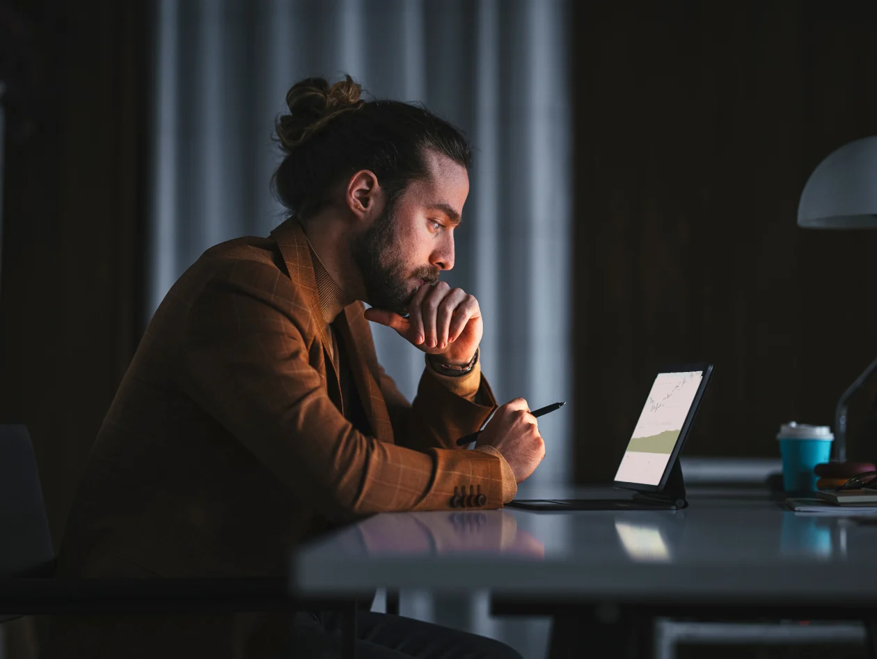 Pensive man in front of a laptop 