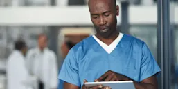 Young medical male nurse consulting the web and working in a hospital or clinic