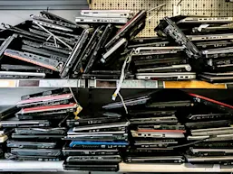 Piles of discarded laptops on a shelf. (Source: Daniel Allan/Image Source via Getty Images)