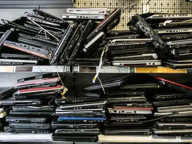 Piles of discarded laptops on a shelf. (Source: Daniel Allan/Image Source via Getty Images)