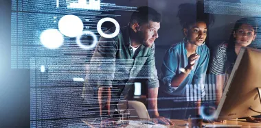 Three people looking at a computer