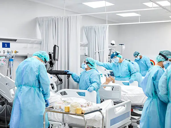 Photo depicting healthcare professionals with protective equipment caring for patients in a hospital setting. (Morsa Images/E+ via Getty Images)