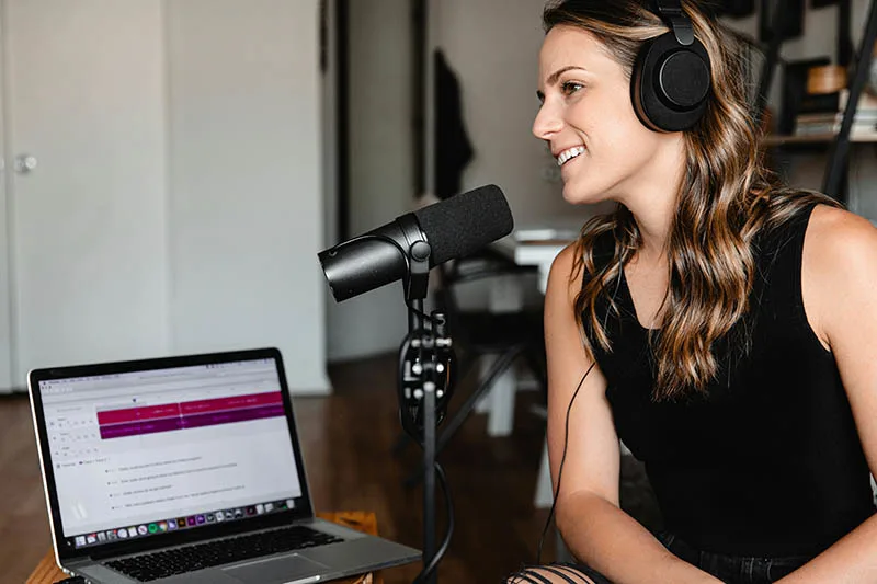 Woman using a good quality microphone with her laptop. (Photo by Soundtrap via Unsplash) 