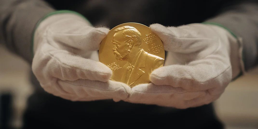 Nobel Prize medal held by gloved hands. © Nobel Prize Outreach. Photo: Clément Morin